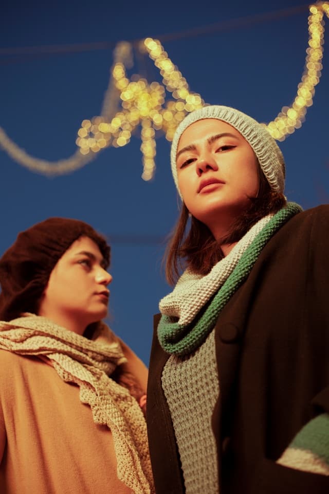 Woman in brown coat and green scarf